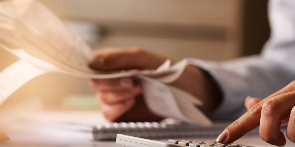closeup-economist-using-calculator-while-going-through-bills-taxes-office