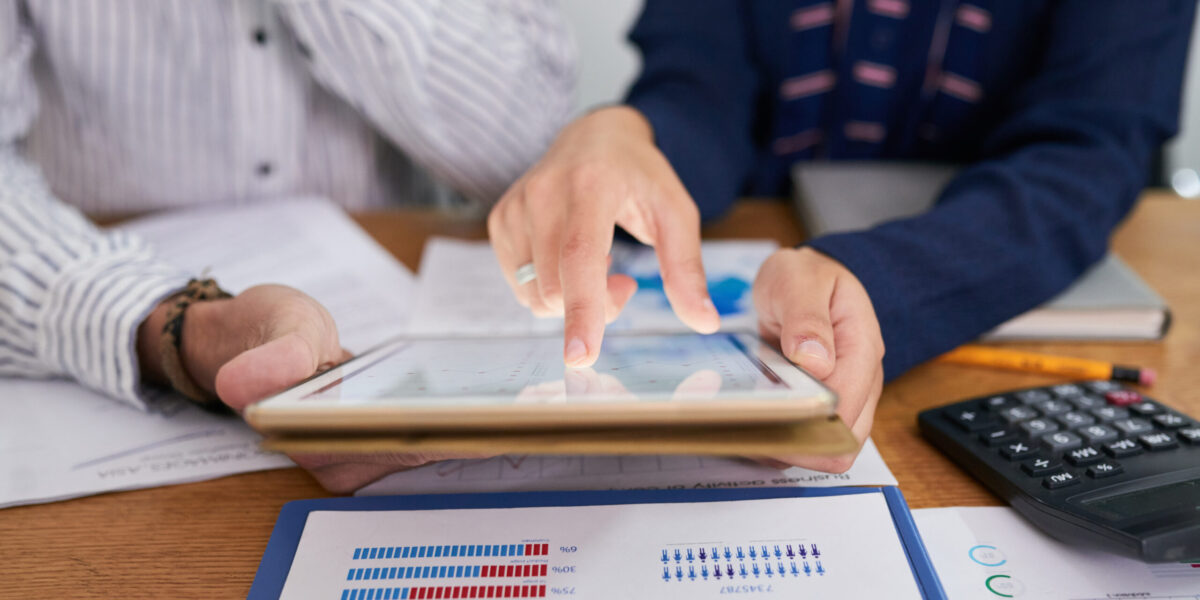 Business people analyzing chart with statistics on tablet computer