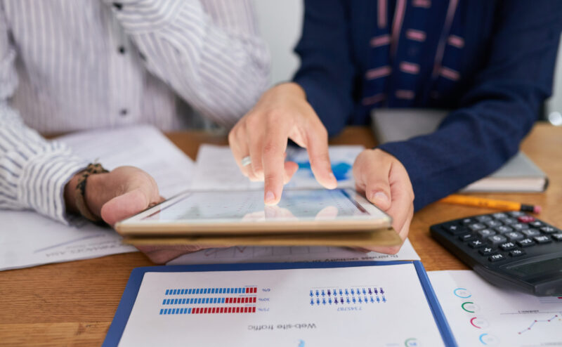 Business people analyzing chart with statistics on tablet computer