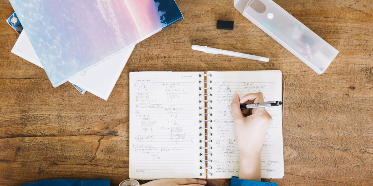 crop-person-writing-notebook